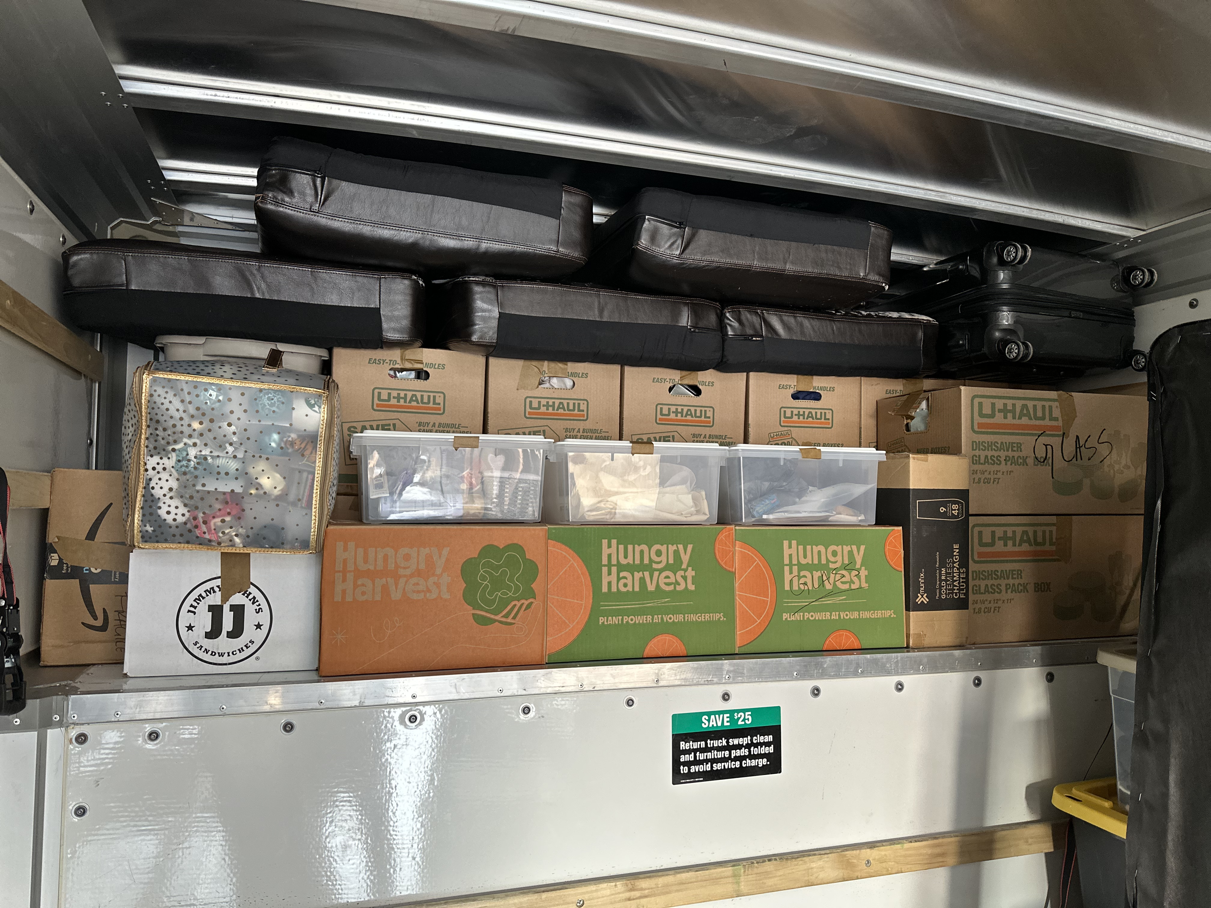 Overhead shelf packed with boxes and bags