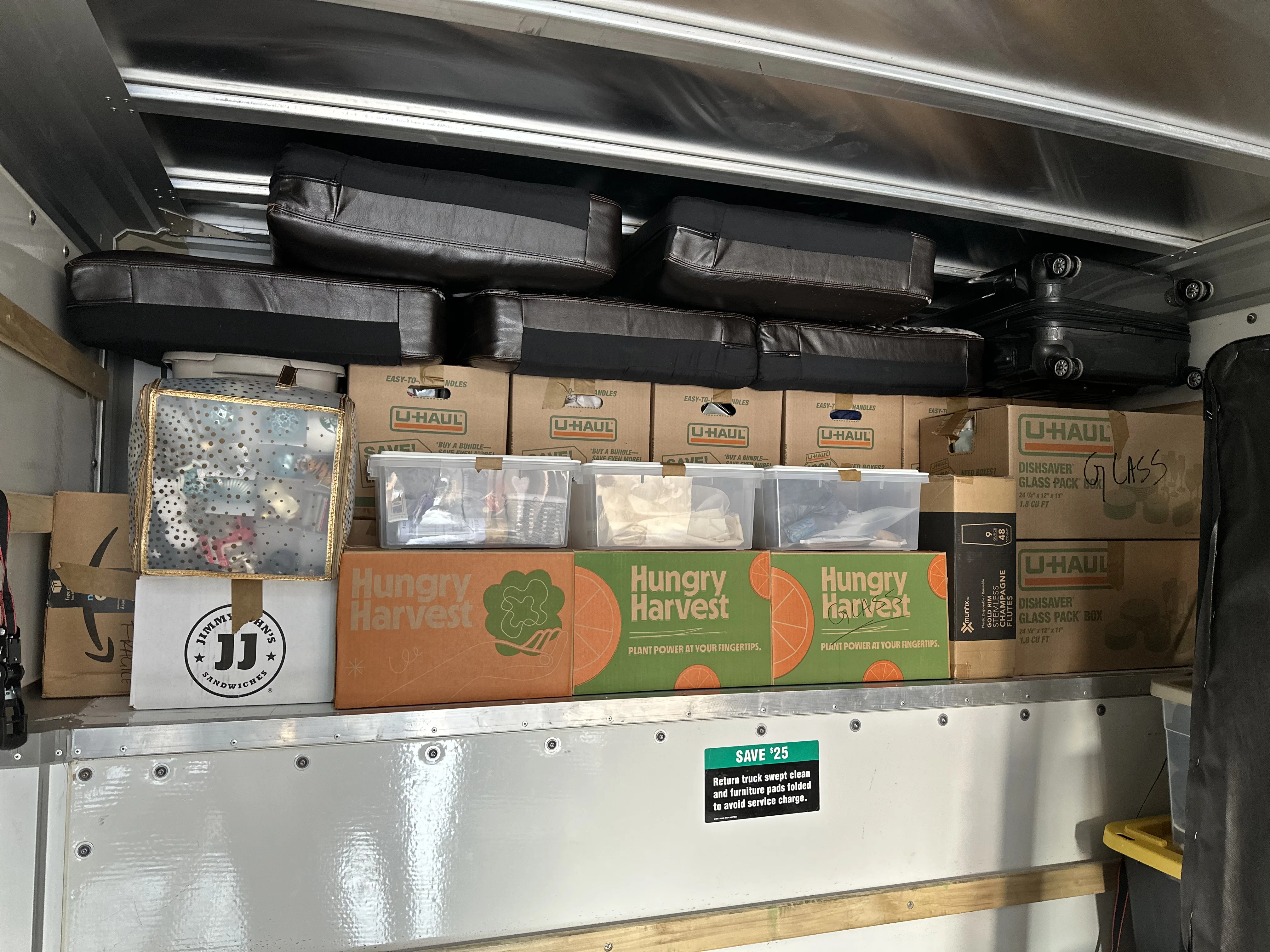 Overhead shelf packed with boxes and bags