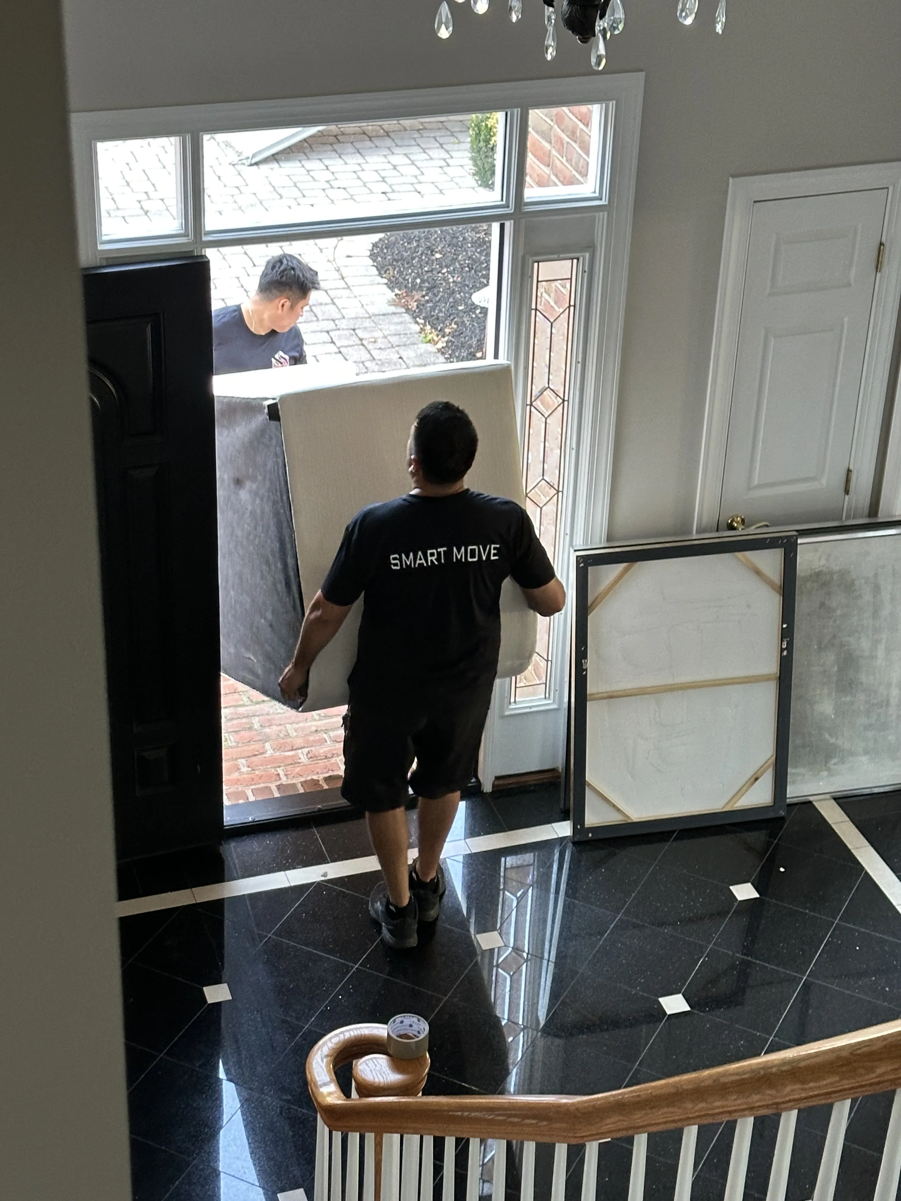 Smart Move crew carrying furniture through front door