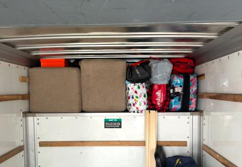 Overhead shelf packed tight with soft goods