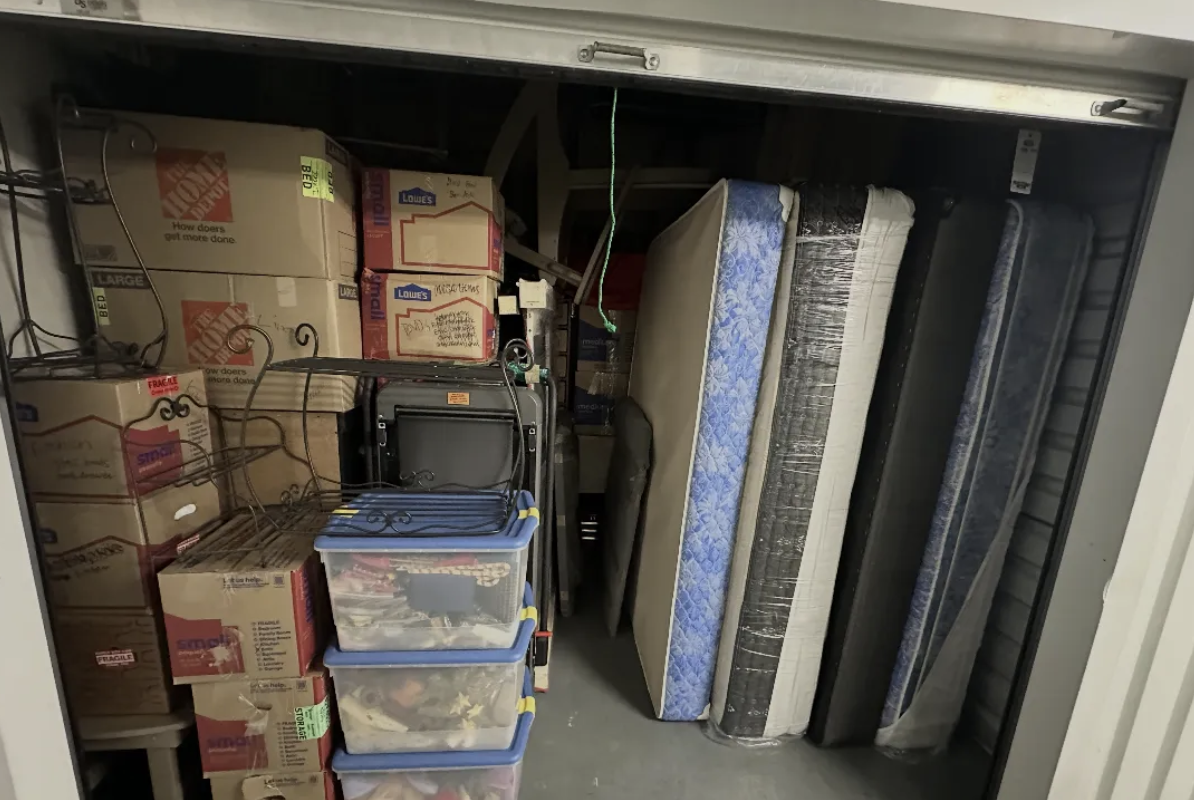 Storage unit packed with labeled boxes and mattresses