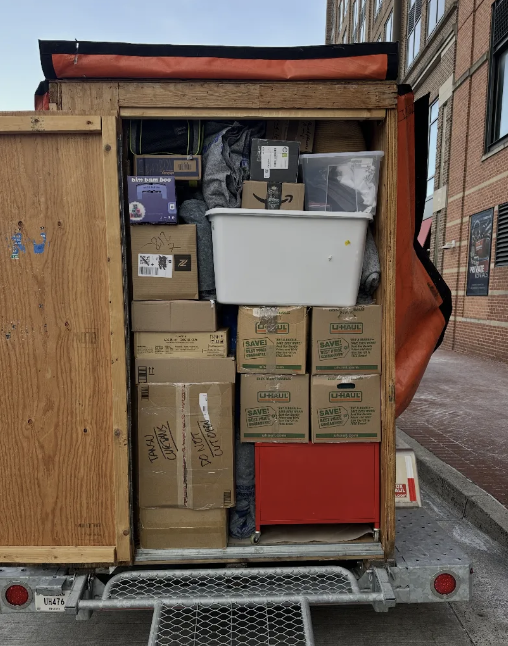 Loaded UBox at urban jobsite — boxes, bins, and totes