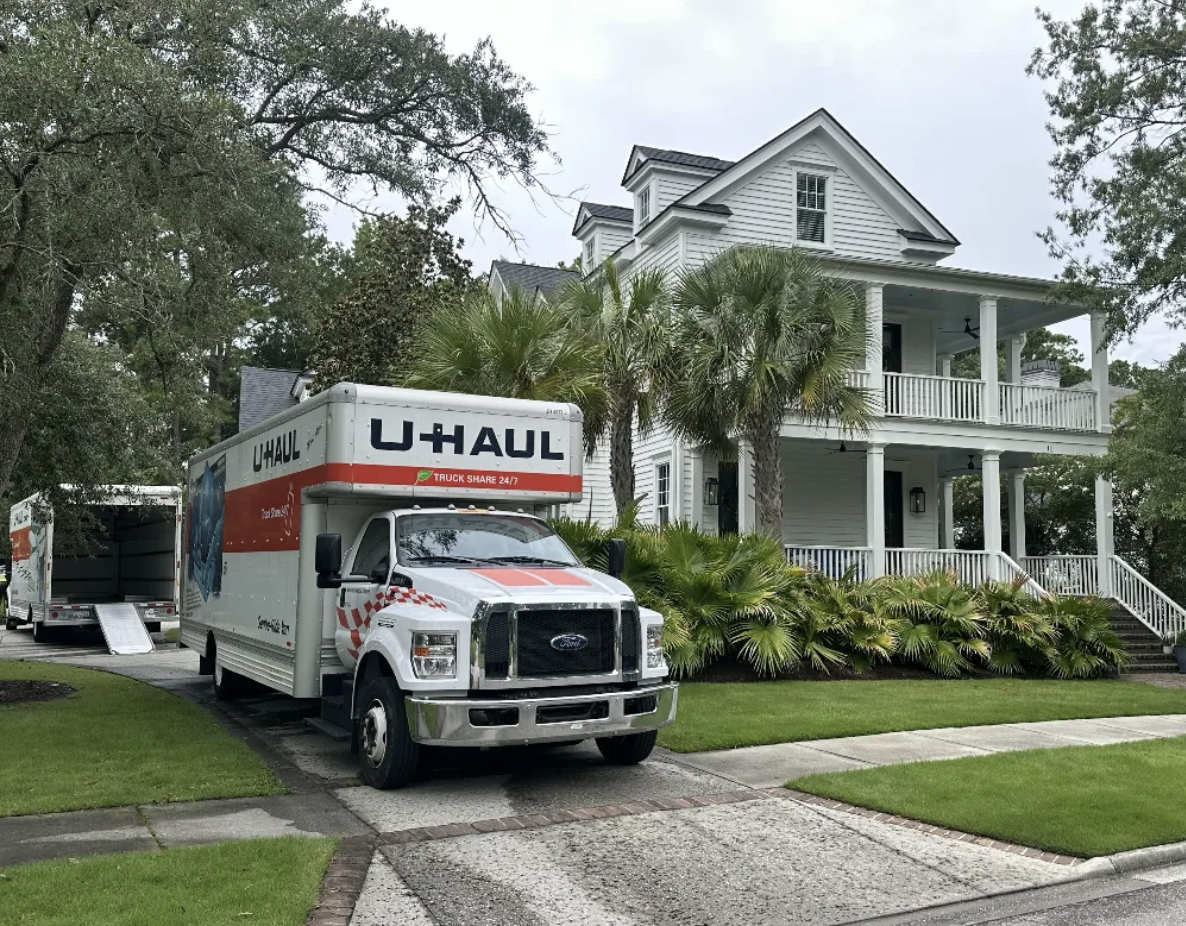 U-Haul truck parked at elegant southern estate with palms