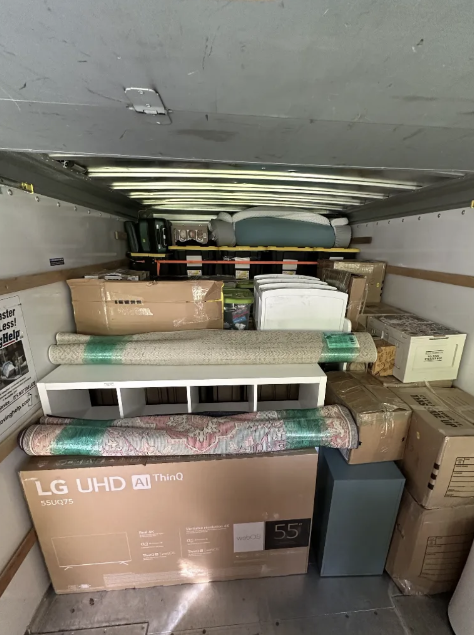 Truck packed with LG TV, rolled rugs, and shelving